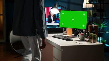 Male freelancer sitting at his desk with copy space screen on computer, browsing the web and enjoys remote work. Young man multitasking and networking, relaxing at home. Camera A. video
