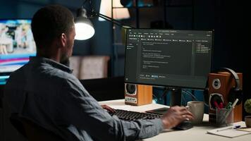 Black man programmer manages code and scripts in artificial intelligence and machine learning on dual monitors computer setup. Male freelancer uses pc to guarantee cyber security. Camera B. video