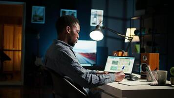 Independent freelancer creates a post it reminder and reviews project data, doing handwritten notes and placing sticky notes to remember his remote tasks. Researching articles. Camera A. video