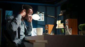 Young focused freelancer attending an online meeting from his home office, discussing with associates remotely. Smiling black man engages in virtual communication, remote technology. Camera A. video