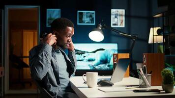 African American guy waving at a call connection with workmates, working remotely from his apartment and participating in executive meetings. Virtual communication. Camera A. video
