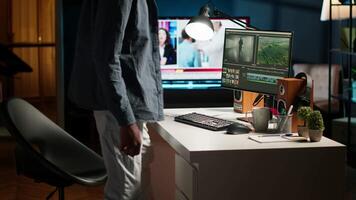 Young filmmaker working on media post production from agency office, ensuring editing timeline and color grading for a shoot. Tech driven workspace showcases a digital workflow. Camera B. video
