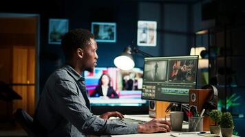 Young filmmaker working on media post production from agency office, ensuring editing timeline and color grading for a shoot. Tech driven workspace showcases a digital workflow. Camera A. video