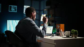 svart man organisering hans schema med en planerare och sätta en påminnelse, skapande ett lim notera posta den och bläddring de webb. modern produktiv kille skrivningar en PM för forskning. kamera a. video