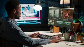 African american videographer works on editing film footage at home, doing freelance contract for post production scenes. Editor correcting white balance and color grading, pc software. Camera B. video