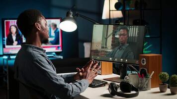African American young guy meeting with his boss to discuss task completion, enjoying remote job from the comfort of his modern loft. Waving on a call online, briefing session. Camera B. video