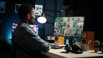 African American man and associates attending a virtual meeting call in his loft, discussing and communicating through a conference, doing remote work at home. Camera A. video