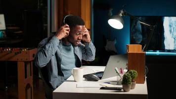 Young focused freelancer attending an online meeting from his home office, discussing with associates remotely. Smiling black man engages in virtual communication, remote technology. Camera B. video