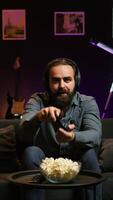Vertical Gamer feeling overjoyed after winning videogame level, screaming in excitement. Ecstatic man at home yelling from joy after achieving victory while playing on gaming console, camera B video
