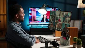 African American man and associates attending a virtual meeting call in his loft, discussing and communicating through a conference, doing remote work at home. Camera B. video