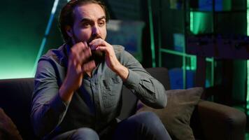 Supporter watching sports match on live broadcast, raging on couch in anger seeing team mistake. Angry man looking at football competition fuming, releasing pent up emotions, camera A video