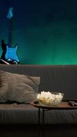 Vertikale Mann eintreten Zimmer, Essen Popcorn während Aufpassen interessant Film auf Streaming Service, genießen Zeit aus. Person Kommen Zuhause zu suchen beim Filme ausgestrahlt auf Fernseher und verbrauchen Snacks, Kamera ein video