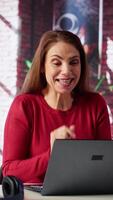 Vertical Happy jolly adult engaging in virtual workshop course via web teleconference, waving at the webcam at home. Woman joining call online for an interactive learning session. Camera A. video