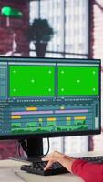 Vertikale konzentriert Editor Frau funktioniert auf Montage Nächster zu Kopieren Raum, kreativ Software auf Desktop beim heim. Filmemacher mit Dual Monitore zu bearbeiten Aufnahmen und erstellen Inhalt, Post Produktion. Kamera a. video