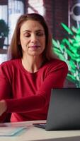 Vertical Woman enjoying remote job and listening to music on headphones, multitasking with focus music for productivity in her apartment. Freelancer likes chill sounds and solving tasks. Camera A. video