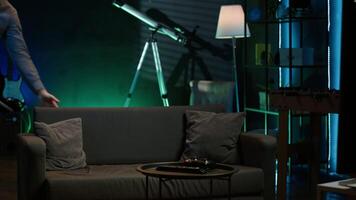 Cheerful gamer rushing home to play newly released game. Happy man jumping on couch, eager to play videogame on console, relaxing after hard day at work, camera A slow motion shot video