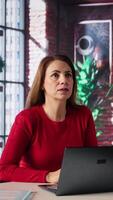 Vertical Focused looking at the hologram visualization to create analysis in loft, virtual interaction with artificial intelligence. Mature woman examines holography image with AI, innovation. Camera B. video
