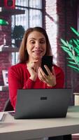 Vertical Woman freelancer taking online course to develop new skills from home office, attend online call and watching lecture on smartphone. Lady participates at virtual training class. Camera B. video