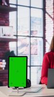 Vertical Confident woman solving tasks on a freelance platform next to mockup screen, answering emails and multitasking. Person staying connected and enjoying flexibility of working from home. Camera B. video