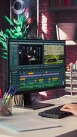 Vertical creator woman editing a music on dual monitors in loft studio, multitasking between timeline editing and color grading. Professional editor uses tech tools and software. Camera B. video