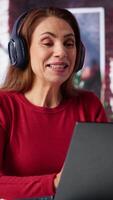 Vertical Joyful woman hosting a virtual family meeting online via conference, meeting with the relatives and sharing latest news. Person uses web connection to keep in touch with loved ones. Camera A. video