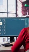 Vertical Technician employs AI chatbot on pc monitor and executing programming code. IT freelance expert using coding software and artificial intelligence to write and test code in her apartment. Camera B. video
