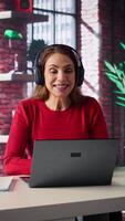 Vertical Joyful woman hosting a virtual family meeting online via conference, meeting with the relatives and sharing latest news. Person uses web connection to keep in touch with loved ones. Camera B. video