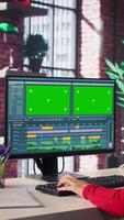 Vertical Focused editor woman works on montage next to copy space, creative software on desktop at home. Filmmaker using dual monitors to edit footage and create content, post production. Camera B. video