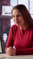 Vertical Excited woman joining online lesson to work on new skills from home desk, attending web conference call and watching lecture from her loft. Adult participates at a virtual training class. Camera A. video