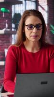 Vertical Freelancer does her research by reading articles and data driven papers at home, collecting information for a new project. Woman multitasking and studying files with handwritten notes. Camera B. video