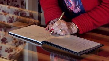 a woman writing on a book with a pen video