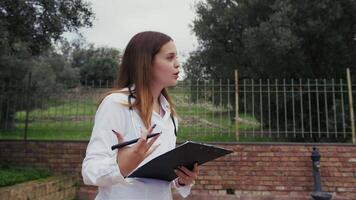 Female Trainee Doctor Practices Interview With Fake Imaginary Patient Outside video