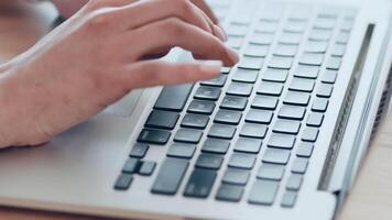 A pair of hands with neatly manicured nails is typing on a laptop keyboard, set against a clean and organized desk. The soft natural light enhances the workspace atmosphere. video