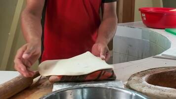The chef prepares dough for cooking dishes in the tandoor video