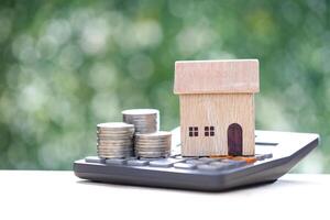 Estate tax,Model house on calculator with on natural green background,Business investment and Property tax concept photo