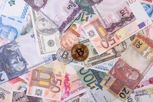 Round metal bitcoin on a background of paper banknotes photo