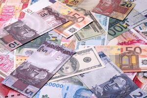 Background consisting of paper banknotes of different currencies photo