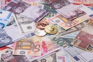 Round bitcoin on a background of paper banknotes of different currencies photo