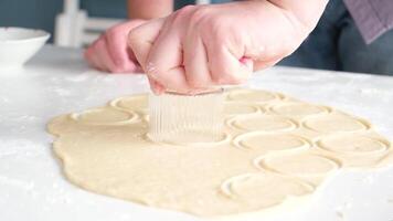 man cutting out small circles in dough in the kitchen video
