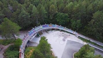 Sarajevo, Bosnia and Herzegovina 08-26-2024, Abandoned Bobsleigh Track in Sarajevo. Aerial view of the facility immersed in nature used for the Sarajevo Winter Olympics of bobsleigh video