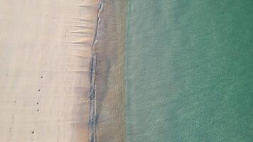 aerial drone view footage descending down onto a beach with turquoise water at sunset, summer concept background video