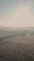 A plane flying over a field with fog in the background video