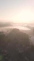 A view of a foggy landscape with a lake and trees video