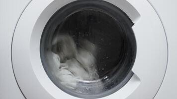 White washing machine filled with casual clothes, in action. Utilizing modern technology and cleaning services to simplify household chores and maintain order video