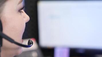 Female call center operator working on computer with headset video