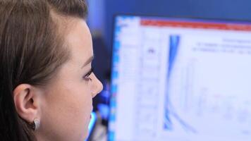 Businesswoman analyzing data on computer screen in office setting video