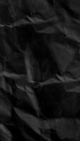Crumpled paper stop motion animation, Textured black paper portrait background. The concept of sketch pad, design, retro style, wrinkle, frayed, blank video