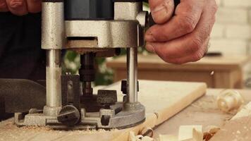 Crafting intricate wood designs using a router tool in a workshop setting video