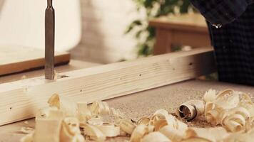 Woodworking project in a workshop with shavings on a table and a craftsman at work video