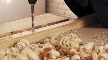 Woodworking technique demonstrated with drill in workshop creating wood shavings and detailed craftsmanship video
